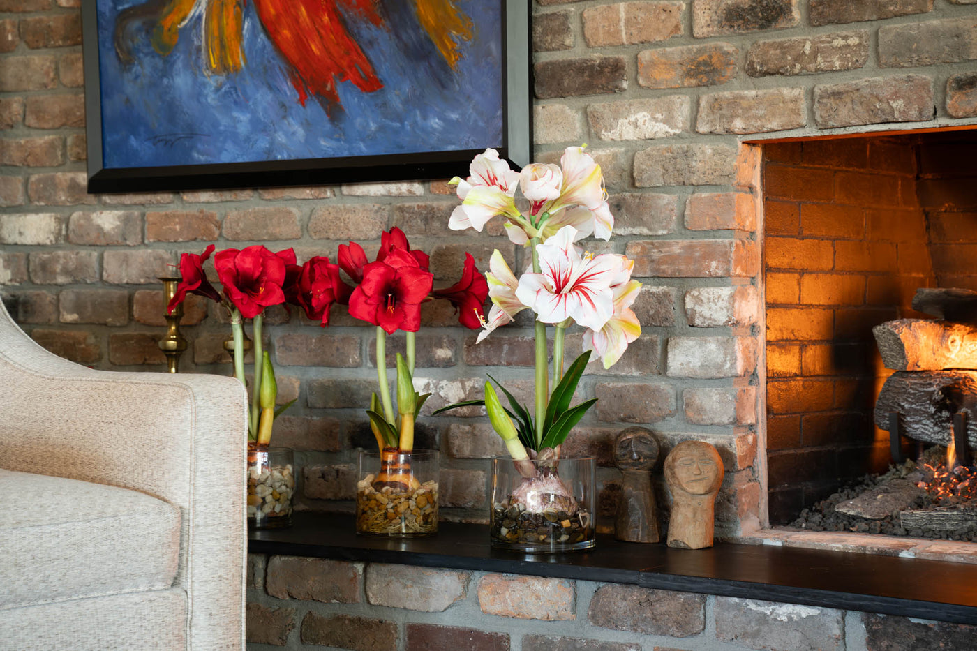 Red and White Amaryllis Artificial Holiday Greenery Next to Fireplace - New Growth Designs