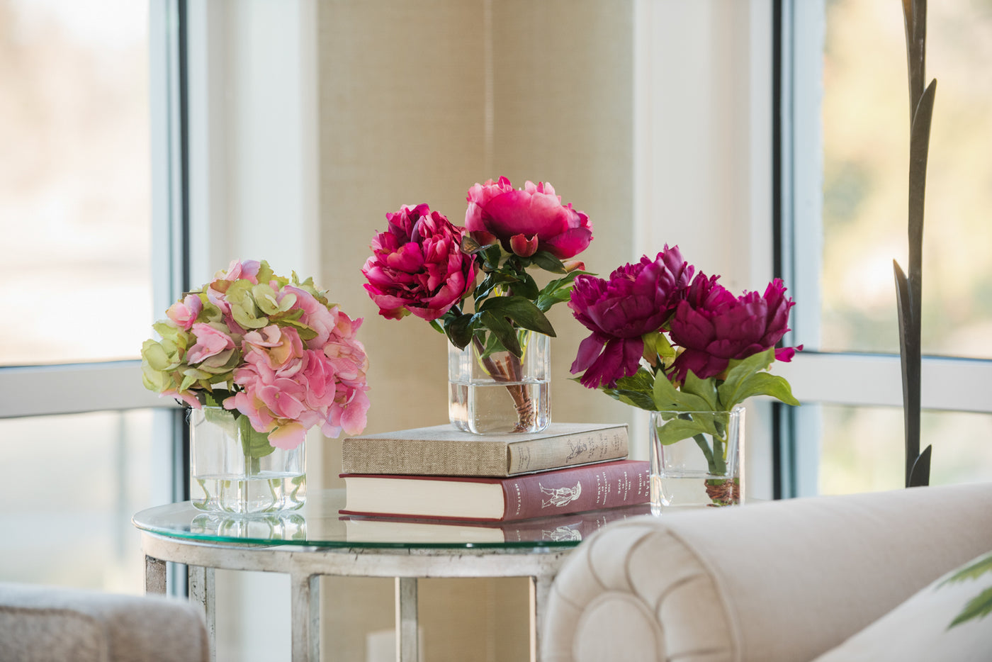 Three Hydrangea and Peony Wholesale Faux Floral Arrangements on Glass Table with Books - New Growth Designs
